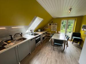 a kitchen with a table and a dining room at Lüly in Lütjensee