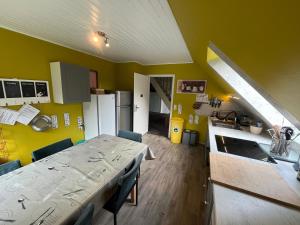 a kitchen with a table and a kitchen with yellow walls at Lüly in Lütjensee +39 photos
