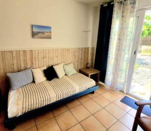 a bed sitting in a room with a window at Résidence le patio - Mimizan plage in Mimizan-Plage