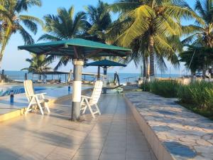 a couple of chairs and a umbrella by a pool at Lois Beach Resort in Nyanyanu