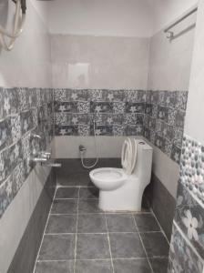 a bathroom with a toilet and a shower in it at Wayan Luxury Rooms in Hyderabad