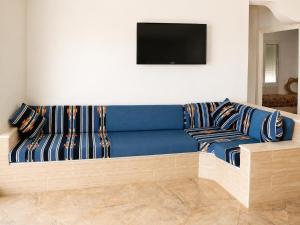 a blue couch with striped pillows in a living room at Luxury Beachfront Villa with Pool and Jacuzzi in Hennchir Ksar Rhaleb