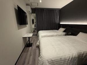 a hotel room with two beds and a table at ホテルいづみや in Aizuwakamatsu +26 photos