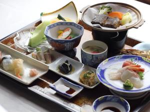 a tray with plates of food on a table at ホテルいづみや in Aizuwakamatsu