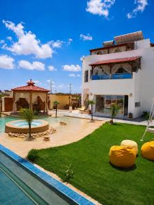 a large building with a swimming pool next to a resort at Luxury Beachfront Villa with Pool and Jacuzzi in Hennchir Ksar Rhaleb