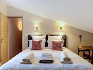 a bedroom with a large white bed with towels on it at Les Petits Princes, expérience unique à Polignac in Polignac