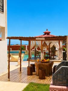 a wooden pergola with a table and a table at Luxury Beachfront Villa with Pool and Jacuzzi in Hennchir Ksar Rhaleb +40 photos