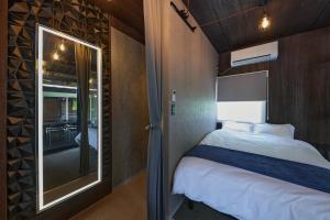 a small bedroom with a bed and a mirror at Sauna Villa Biwako Forest Bathing in Takashima +58 photos