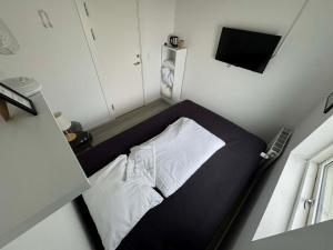 a small bedroom with a bed and a television at Slottets Anneks in Rønne