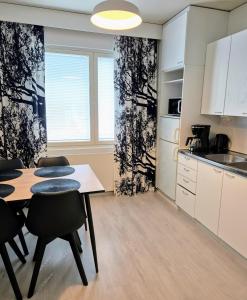 a kitchen and dining room with a table and chairs at Citykoti Kuutti in Savonlinna