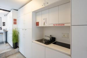 a kitchen with white cabinets and a sink at Casa Riccobon in Koper