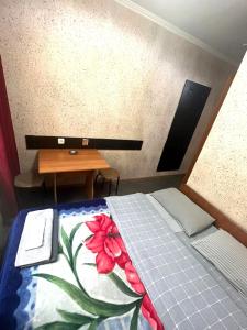 a bedroom with a bed with a flower blanket at Гостиница Гулдер in Almaty