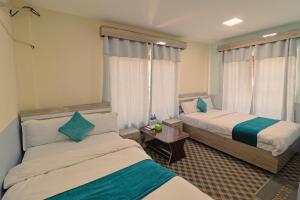 a hotel room with two beds and a window at Manthali Park Inn in Rāmechhāp +30 photos