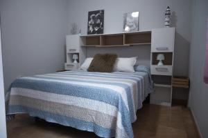 a bedroom with a bed with a blue and white blanket at Parque 27 in Cartagena