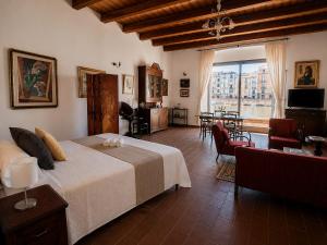 a bedroom with a large bed and a living room at Bosa Exclusive Apartments "Bosa Apartments" in Bosa