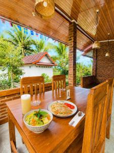 a wooden table with two plates of food on it at Eleen Bungalow in Tetebatu