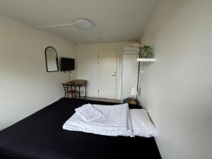a bedroom with a bed with a white comforter at Slottets Anneks in Rønne