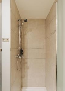 a shower with a shower head in a bathroom at Piulet Hostel in Barcelona +36 photos