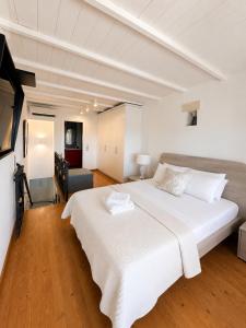 a bedroom with a large white bed and a television at Kytheros in Potamós