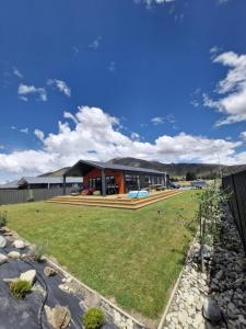 a house with a large backyard with a yard at Modern Omarama Getaway in Omarama