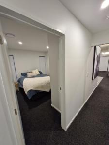 a small bedroom with a bed and a hallway at Modern Omarama Getaway in Omarama