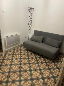 a living room with a couch and a floor at Small renovated cozy spot in Palavas-les-Flots
