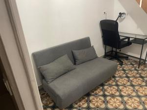 a gray couch sitting in a room with a desk at Small renovated cozy spot in Palavas-les-Flots