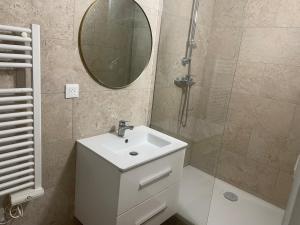 a bathroom with a sink and a shower with a mirror at Small renovated cozy spot in Palavas-les-Flots