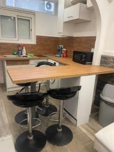 a kitchen with a counter with two bar stools at Small renovated cozy spot in Palavas-les-Flots