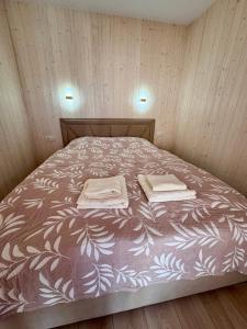 a bed with two towels on it in a room at EL House in Karakol