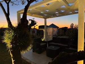 a patio with a white pergola with a couch and a table at Residenza De Vita in Tropea