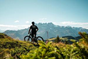 a man riding a bike on a hill at Les Évouettes Châtel village in Châtel