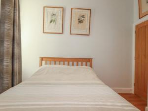 a bed in a bedroom with two pictures on the wall at Farthings, The Old Chapel in St Austell +4 photos