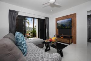 a living room with a couch and a table at Baan Chom View Kamala - SHA Plus in Kamala Beach