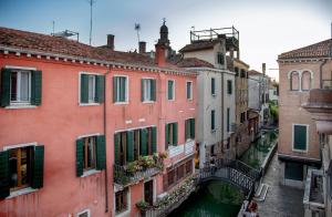 Blick auf eine Gasse mit Gebäuden und einer Brücke in der Unterkunft Hotel Casa W in Venedig