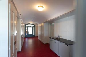 a kitchen with a sink and a red floor at Centrally Located Room in Buchs