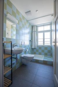 a bathroom with a sink and a toilet and a window at Centrally Located Room in Buchs