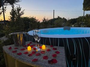 a table with a glass of wine and roses next to a tub at Residenza De Vita in Tropea