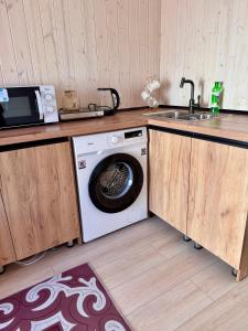 a kitchen with a washing machine and a sink at EL House in Karakol