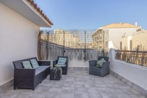 a balcony with two chairs and a couch on a roof at Cambrils in Cambrils