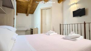 a bedroom with a large bed with towels on it at Il Volto, Terre Marine in Pignone