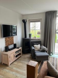 a living room with a couch and a fireplace at Weidevilla 16 in Hollum