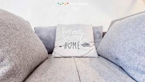 a pillow on a couch with a be forever sweet home at Il Volto, Terre Marine in Pignone