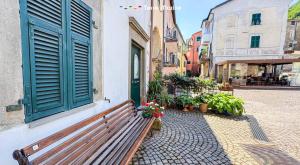 a wooden bench next to a building with a window at Il Volto, Terre Marine in Pignone