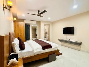a bedroom with a bed and a flat screen tv at Hotel Sunshine Apartment in Bathinda