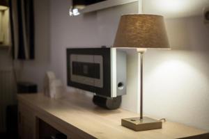 a computer monitor sitting on a table next to a lamp at Weidevilla XXXL in Hollum