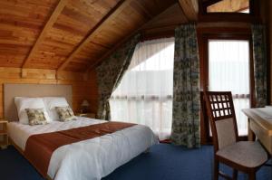 Un dormitorio con una cama y una ventana grande. en Chalet Mont Blanc, en Yaremche