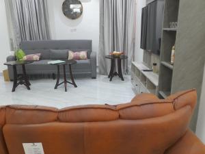 a living room with a couch and a tv at 5and6 Apartments in Abuja +4 photos