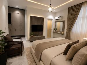 a bedroom with a large bed and a television at 5and6 Apartments in Abuja