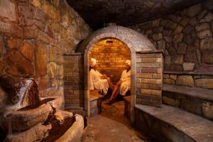 two people sitting in an archway in a stone building at Thermae Sylla Spa & Wellness Hotel in Loutra Edipsou +62 photos